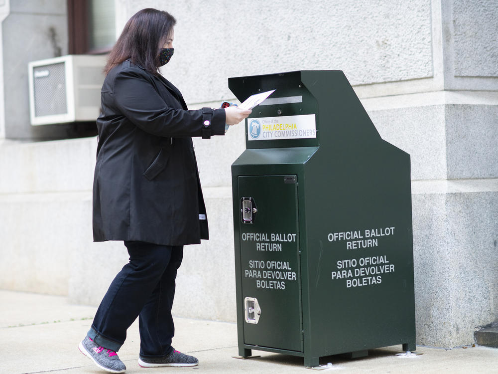 A voter casts her early-voting ballot at a drop box outside City Hall in Philadelphia on Oct. 17.