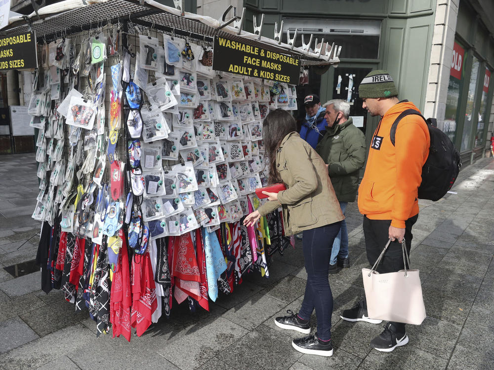 Shoppers buy face masks on O'Connell Street in Dublin, Ireland, on Tuesday. Ireland's government is putting the country at its highest level of coronavirus restrictions for six weeks in a bid to combat a rise in infections.