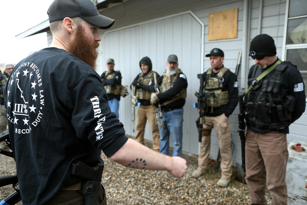 Nicolas Gatejen, left, talks to other members of the Real 3%ers Idaho after a convoy protection drill in western Idaho in January.