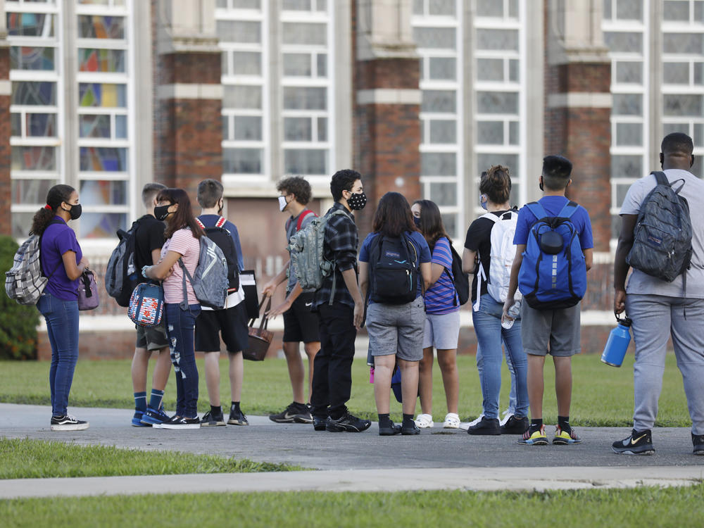 Students at Hillsborough High School in Tampa, Fla., wait in line to have their temperatures checked on Aug. 31. According to an updated tracker, Florida is one of three states that will offer full-time, in-person learning to more than 75% of students by Election Day.