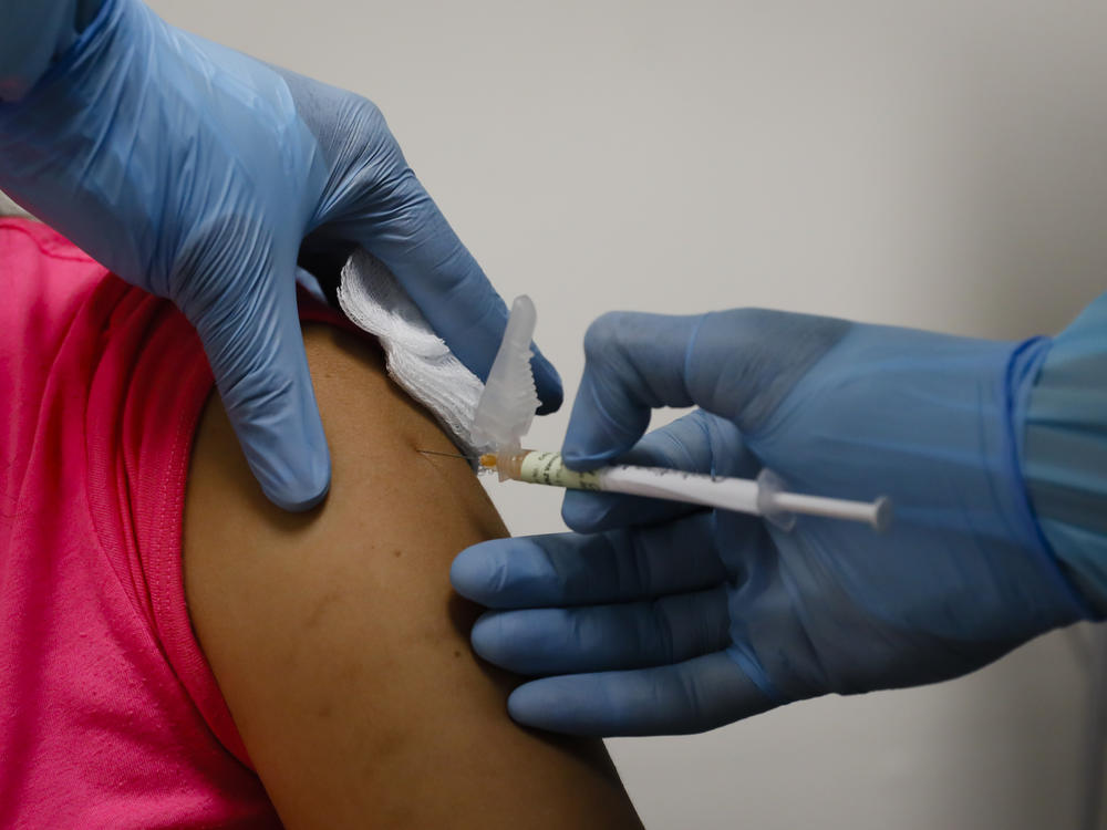 A health worker injects a woman during clinical trials for a COVID-19 vaccine last month in Hollywood, Fla.