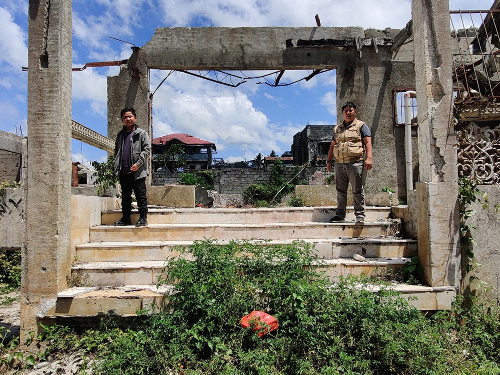 Zaqqir Ali Pacasum, 13, and Nawaz K. Lucman, 28 — Mustapha Alauya L. Pacasum's son and cousin, respectively — stand outside their destroyed ancestral home in Marawi City earlier this year.