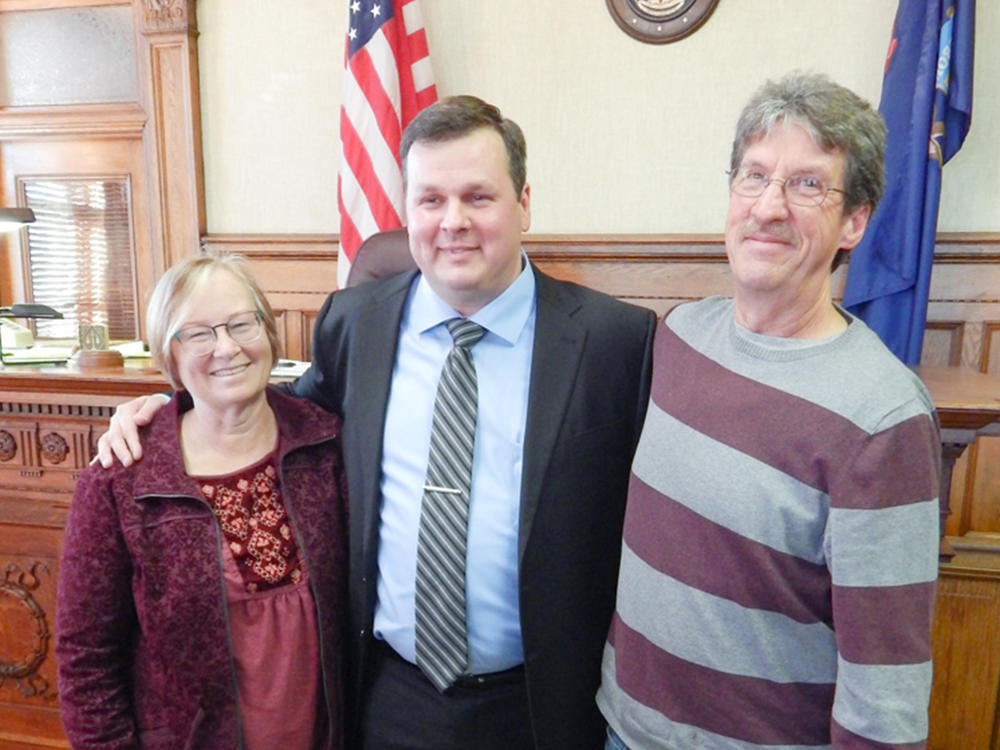 Left photo: Becky McKenney, left, and Mike McKenney, right, visit Bob VanSumeren while he was incarcerated. The couple are parents to Bob's former girlfriend, Jillian, who has also remained close to Bob. Right photo: Becky, Bob and Mike on the day that Bob was sworn in as an attorney.