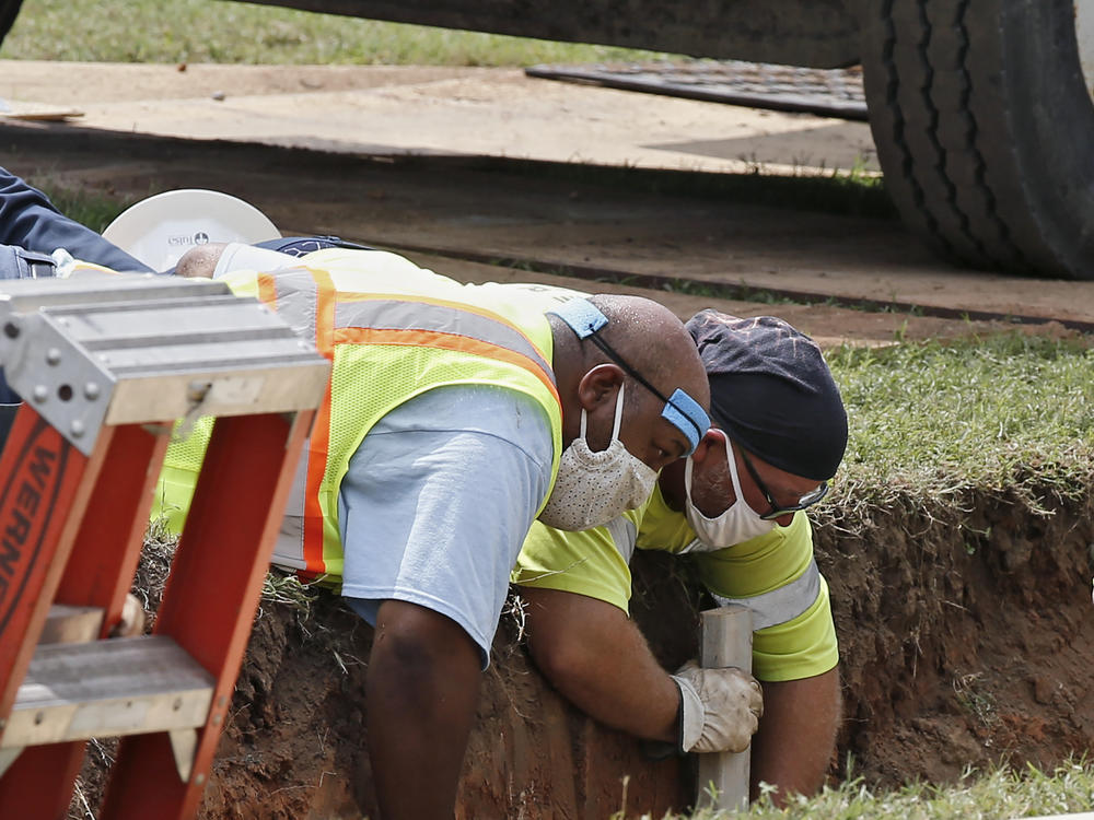 Workers reinforce the sides of an excavation site during the search for a potential unmarked mass grave from the 1921 Tulsa Race Massacre, at Oaklawn Cemetery in Tulsa, Okla., in July.