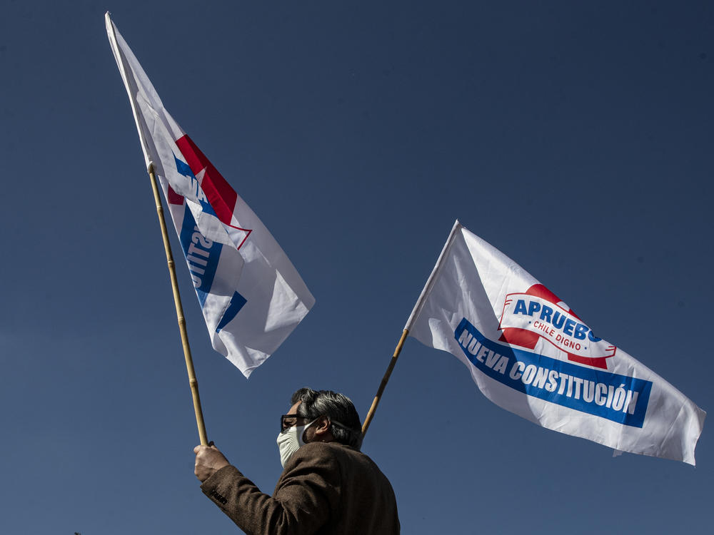 A man waves campaign flags in favor of a new constitution ahead of a referendum on the matter in Santiago, Chile, on Aug. 26. In a referendum on Sunday, Chileans will vote whether to scrap the constitution from the dictatorship of Gen. Augusto Pinochet.