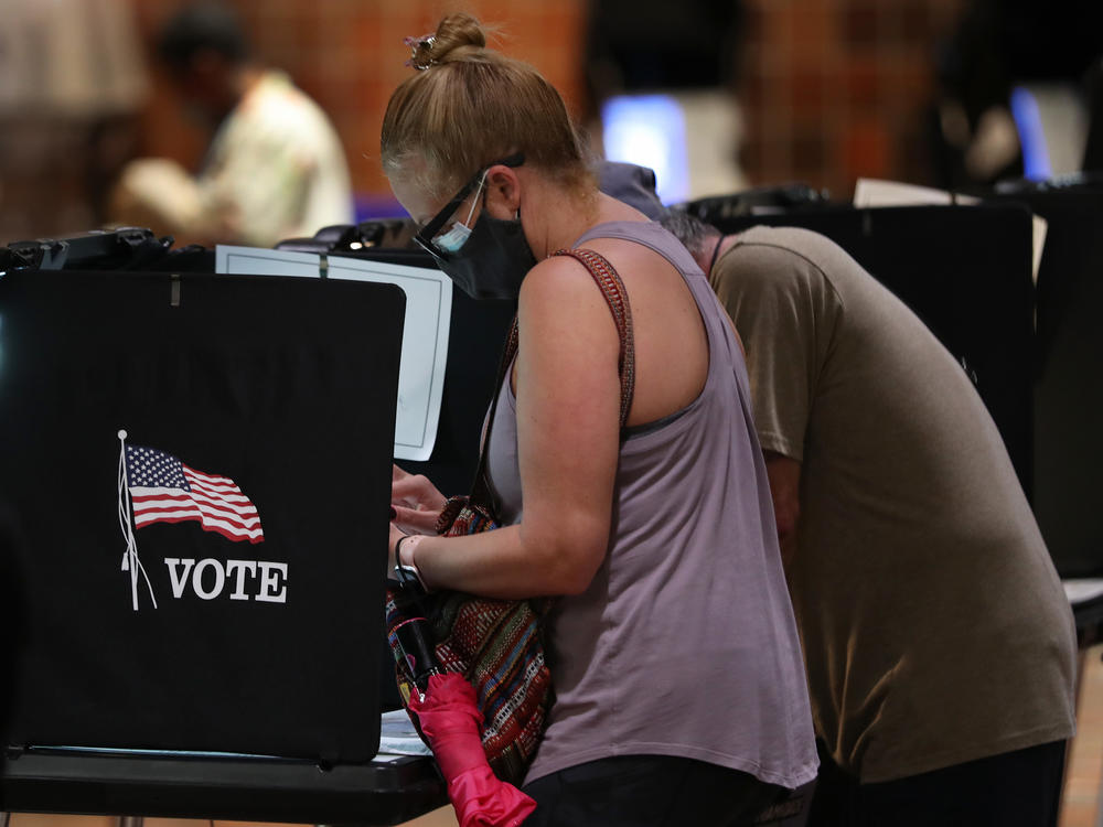 Voters fill out their ballots in Miami this week. Pandemic-driven changes to voting have led to a flood of disinformation about the election process.