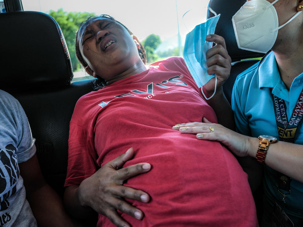 Midwife Merissa Tuping, right, assists Risa Calibuso, who is in labor, with her breathing while the reporter drove her to the nearest hospital. Because of the Philippine law against home birth, the midwife would not deliver the child in Calibuso's residence.