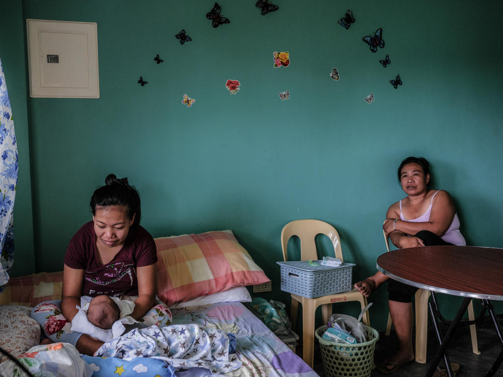 Mylene Madawat, 24, holds her newborn son. Her mother, Minda, right, is by her side. Because Madawat does not live near a health-care facility and home births are against the law in the Philippines, she rented an apartment in a community that has a hospital where she could give birth.