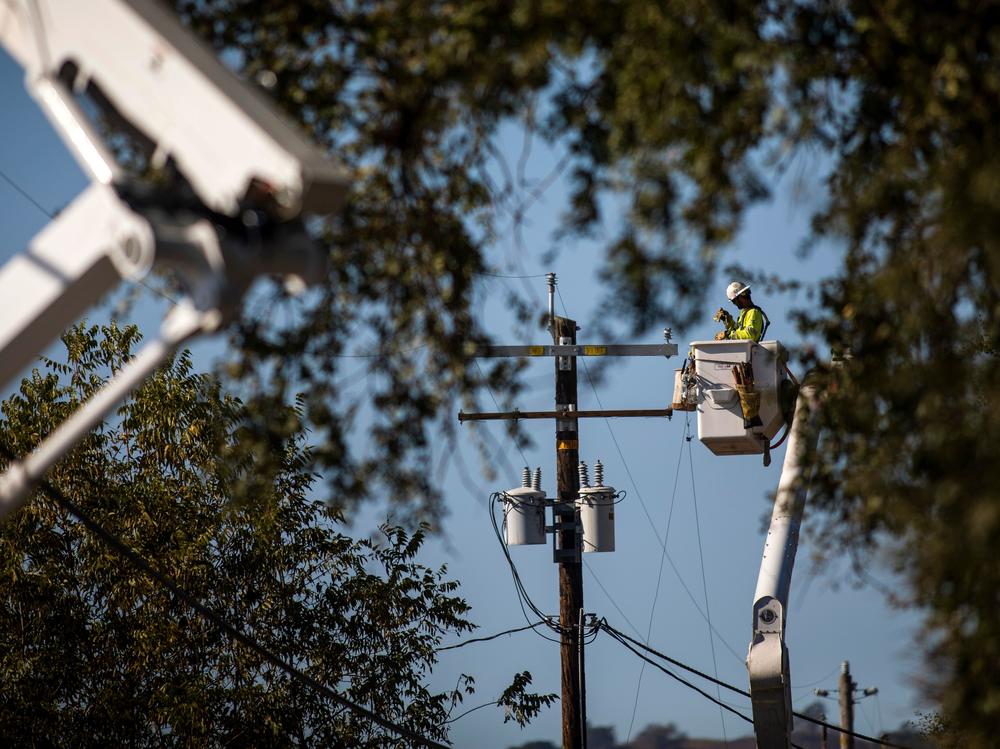 A PG&E contractor works on utility poles along Highway 128 near Geyserville, Calif., on October 31, 2019. The utility is shutting off power for hundreds of thousands in an effort to not spark wildfires.