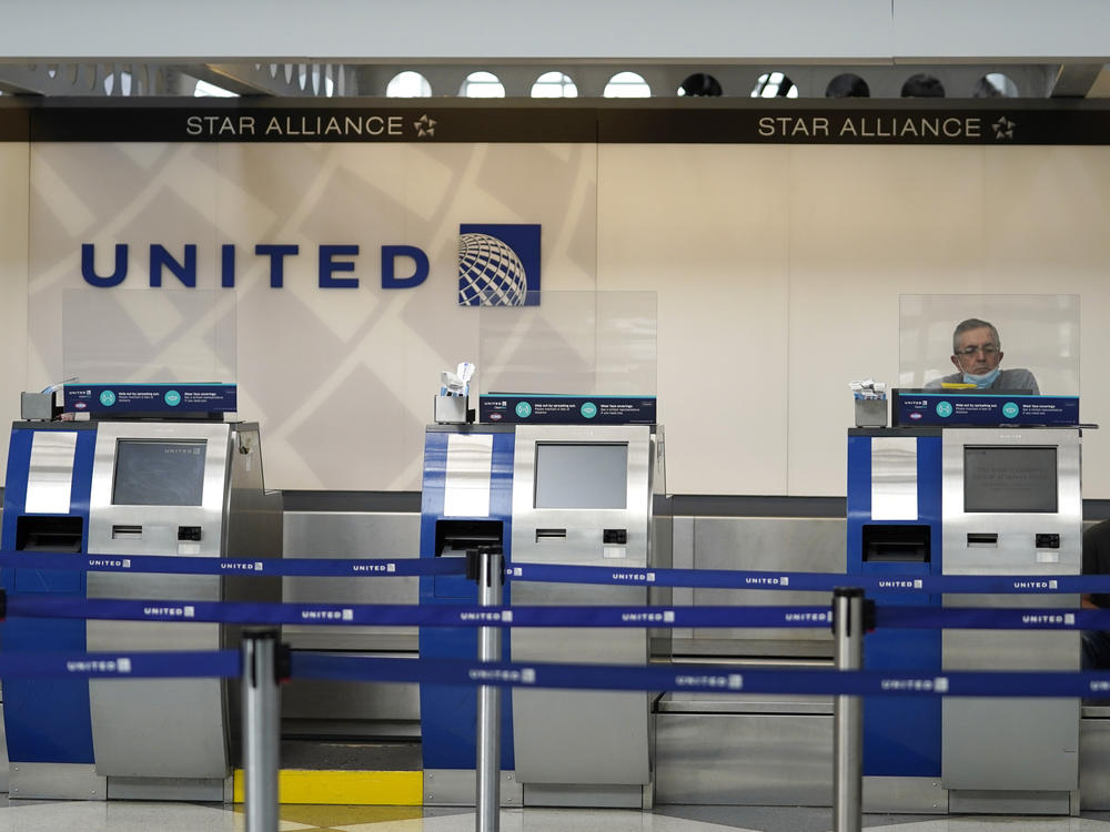 United Airlines employees work at ticket counters at Chicago's O'Hare International Airport on Oct. 14. United and other airline stocks have been hard-hit by the pandemic economic slowdown.