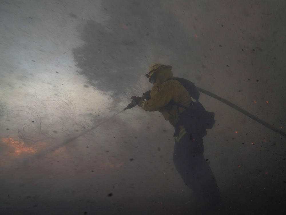 A firefighter battles the Silverado Fire Monday,in Irvine, Calif. The wildfire forced evacuation orders for 60,000 people in Southern California.