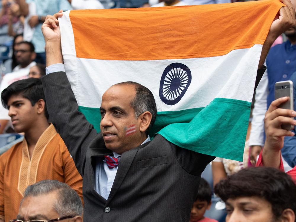 A man holds up an Indian flag during a rally with President Trump and Prime Minister Modi in Houston in September 2019. Trump and Modi have spoken of their friendship, but most Indian Americans say U.S.-India ties are low on their political priorities.