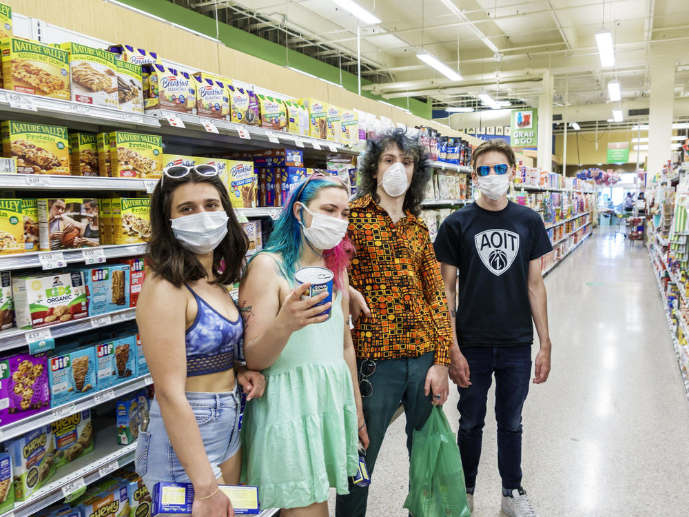 Increasingly, many people in the U.S., like these teens in a Miami grocery story in August, now routinely wear face masks in public to help stop COVID-19's spread. But social distancing and other public health measures have been slower to catch on, especially among young adults, a national survey finds.
