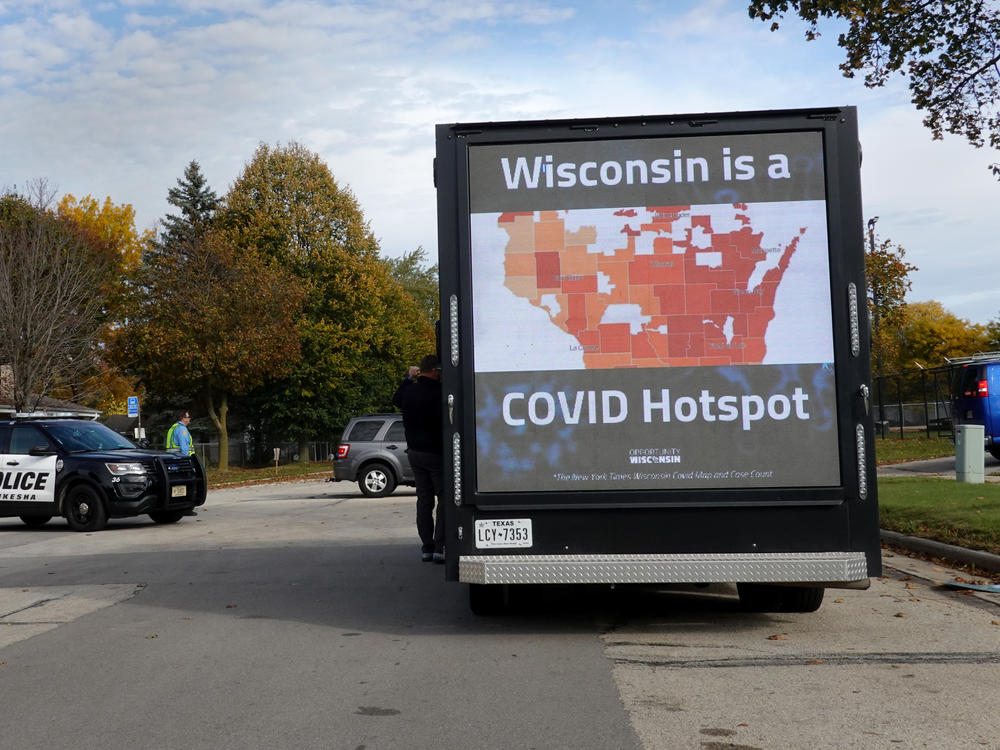 Police stand guard outside of a rally with Vice President Pence  on Oct. 13 in Waukesha, Wis. The state is experiencing a surge of COVID-19 cases, threatening to overwhelm rural hospitals.
