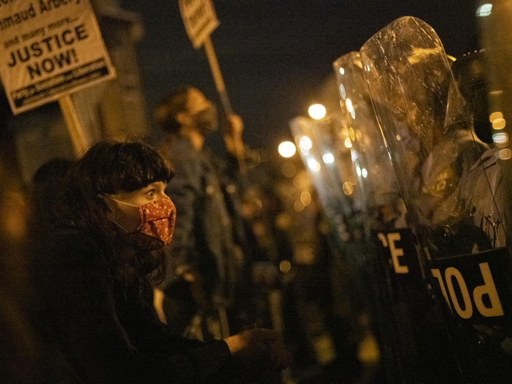 A demonstrator confronts police officers during a protest against the shooting of 27-year-old Walter Wallace.
