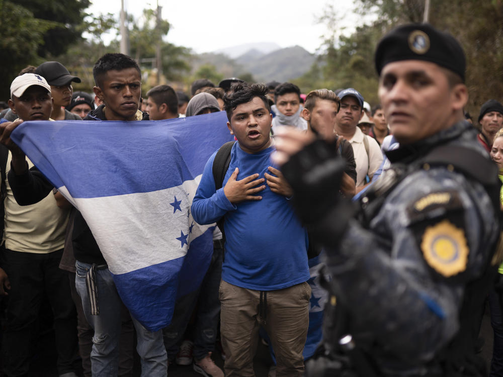 Honduran migrants walking in a group stop before Guatemalan police in January near Agua Caliente, Guatemala. The Democratic staff of the Senate Foreign Relations Committee says U.S. immigration agents in Guatemala helped officials deport Hondurans traveling in a migrant caravan earlier this year.