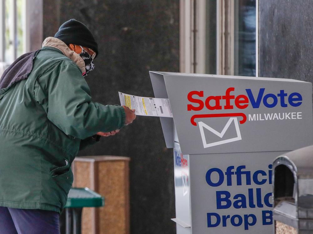 A woman casts her ballot on the first day of in-person early voting for the 2020 elections in Milwaukee on Oct. 20. With just days left until Election Day, both President Trump and Democratic presidential nominee Joe Biden will head to the Badger State for dueling campaign events on Friday.