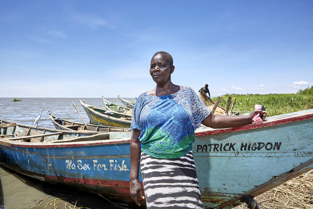 Justine Adhiambo Obura is a leader in the No Sex For Fish program. She stands in front of one of the 30 boats that were obtained for local women with grant money, so they could own their own vessels and hire men to fish for them. The goal is to stop the practice of fishermen demanding sex in exchange for entrusting their catch to a woman fishmonger to sell.