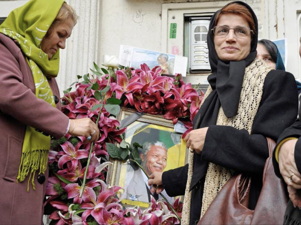 Iranian human rights lawyer Nasrin Sotoudeh with a poster of South Africa's Nelson Mandela, in a scene from the <em>Nasrin </em>documentary.