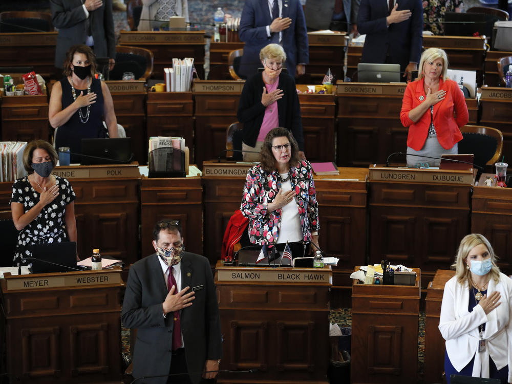 State representatives stand during the Pledge of Allegiance in the Iowa House chambers in Des Moines, Iowa, in June.