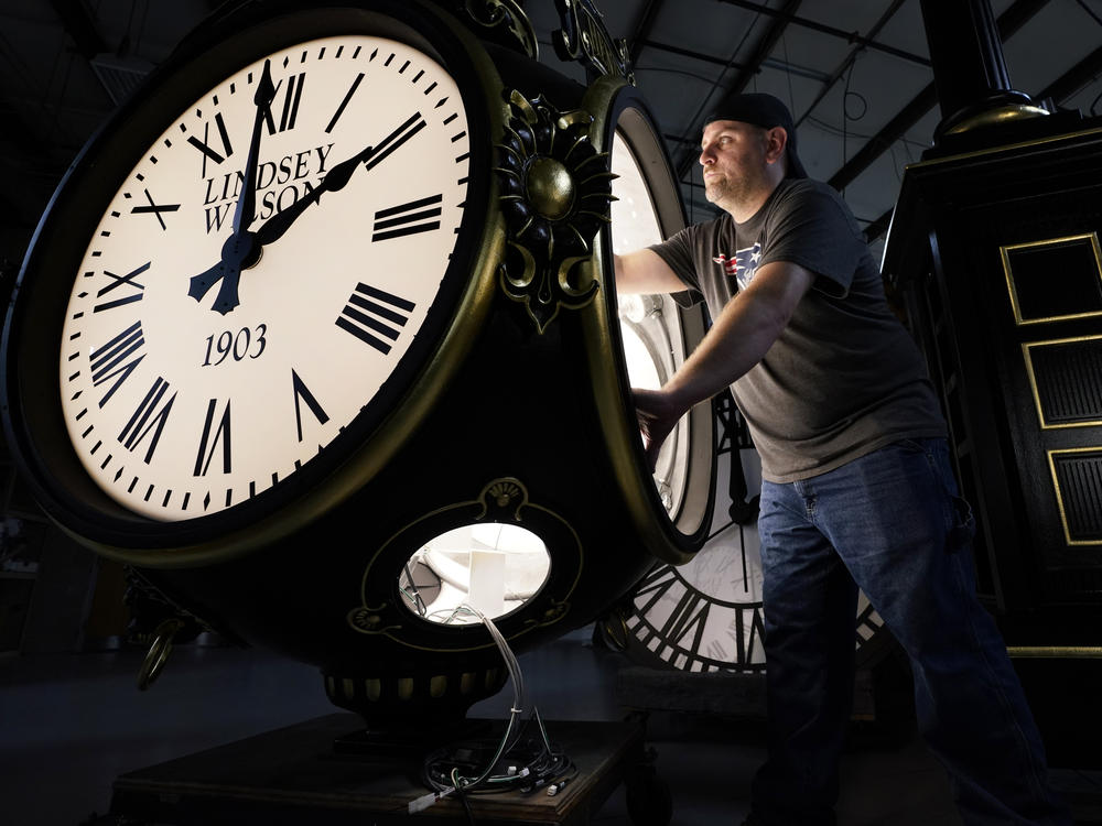 Dan LaMoore works on a Seth Thomas Post Clock at Electric Time Company on Oct. 23, in Medfield, Mass. Daylight saving time ends at 2 a.m. local time Sunday.
