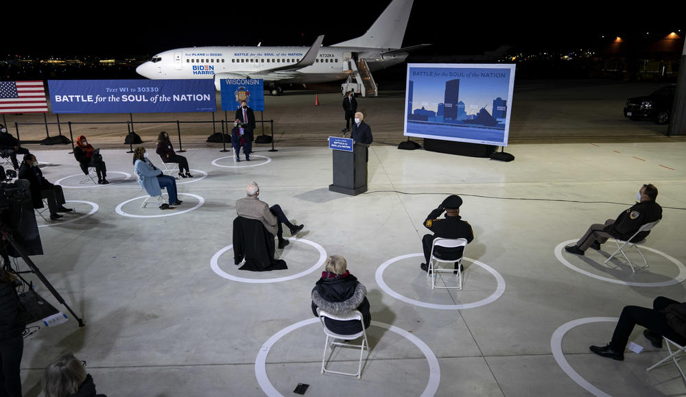 With a socially distanced audience of supporters and journalists, Democratic presidential nominee Joe Biden delivers remarks at Milwaukee Mitchell International Airport in Wisconsin on Friday.