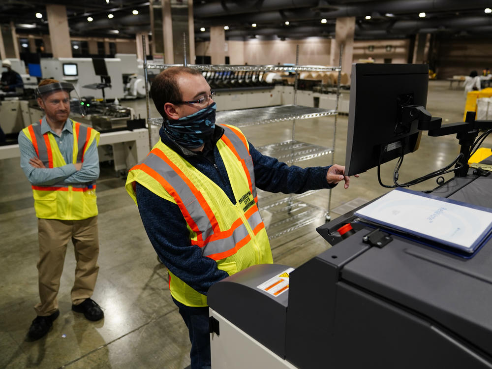 John Hansberry with the Philadelphia City Commissioners Office runs a sorting machine at the city's mail-in ballot sorting and counting center on Oct. 26.