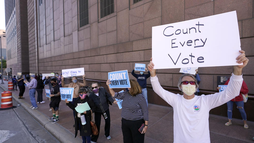 Demonstrators stand across the street from the federal courthouse in Houston, Monday, Nov. 2, 2020, before a hearing in federal court involving drive-thru ballots cast in Harris County.