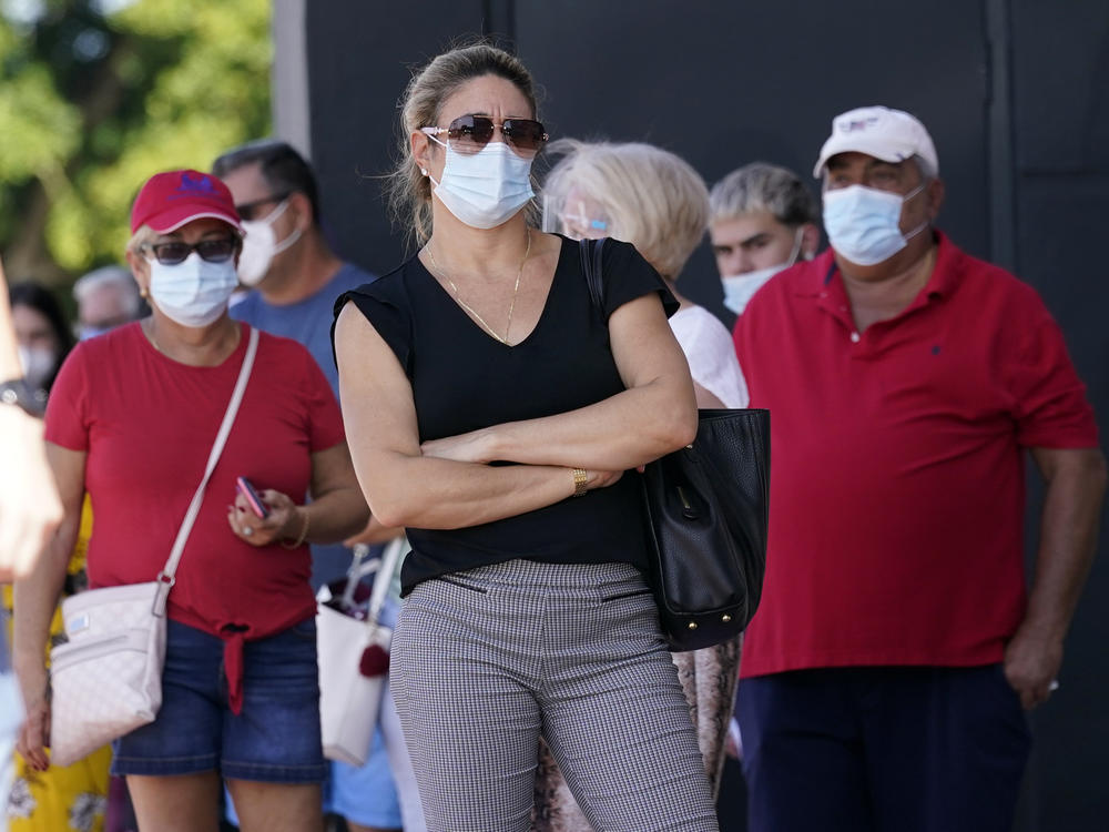 People stand in line for early voting at the John F. Kennedy Library on Oct. 27 in Hialeah, Fla.