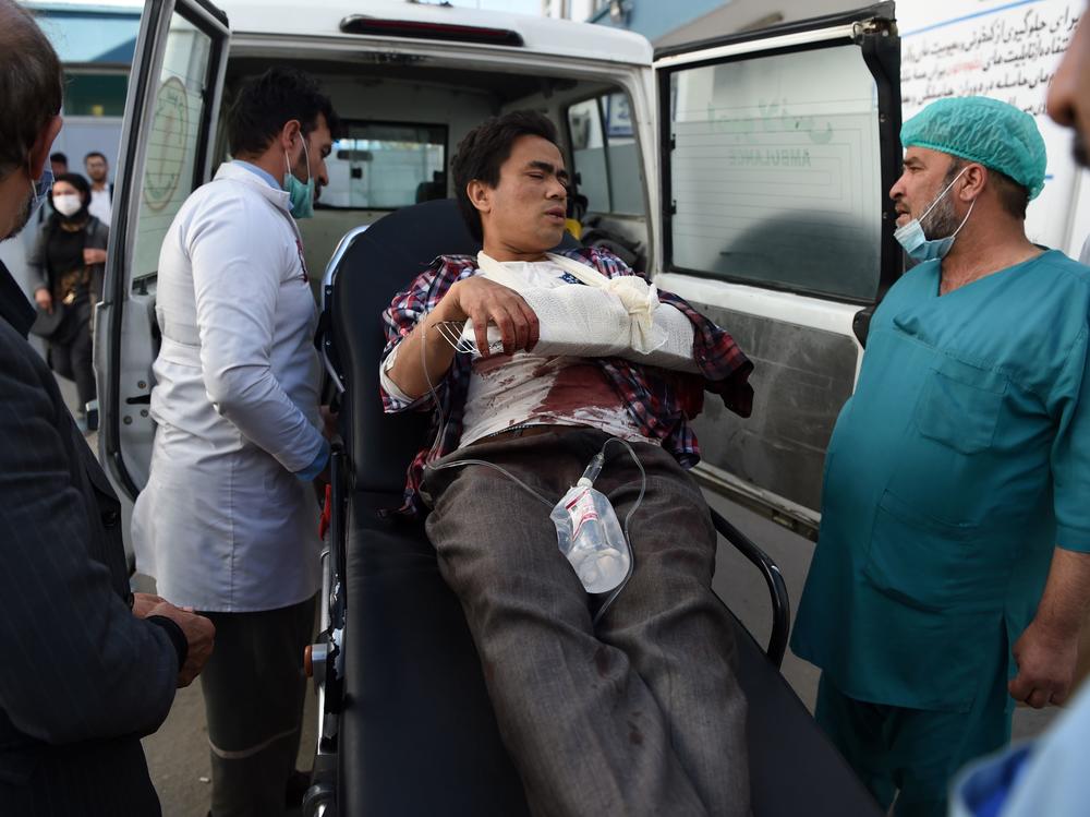 A man, wounded after gunmen stormed Kabul University, arrives in an ambulance at Isteqlal Hospital on Monday. At least 19 people died in the attack on Afghanistan's largest university.