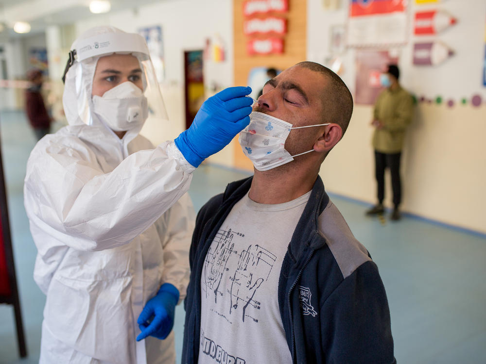 A man is tested for the coronavirus on Sunday in Košice, Slovakia, as part of a nationwide effort to test nearly everyone over age 10 for the virus.