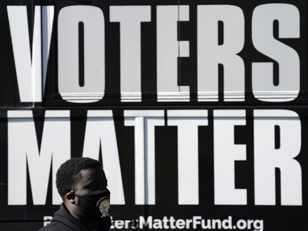 A man wearing a mask at an Election Day rally at the Graham Civic Center polling site in Graham, N.C.
