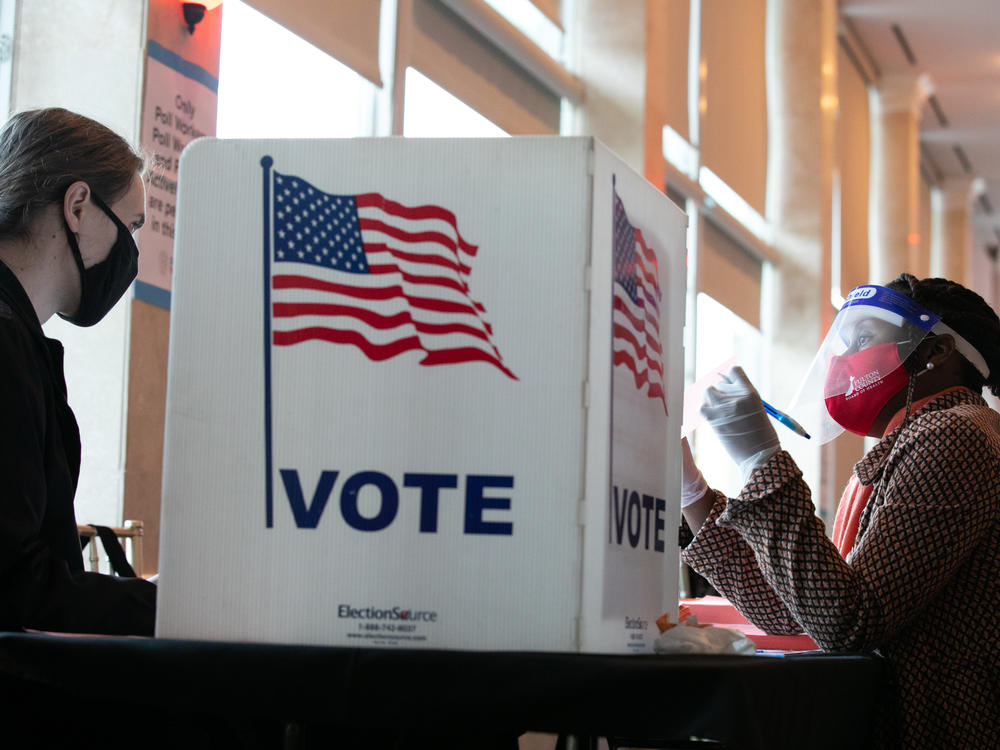 A poll worker helps K. Maki (left) fill out a provisional ballot at Park Tavern polling station on Tuesday in Atlanta, Ga. After a record-breaking early voting turnout, Americans head to the polls on the last day to cast their vote.