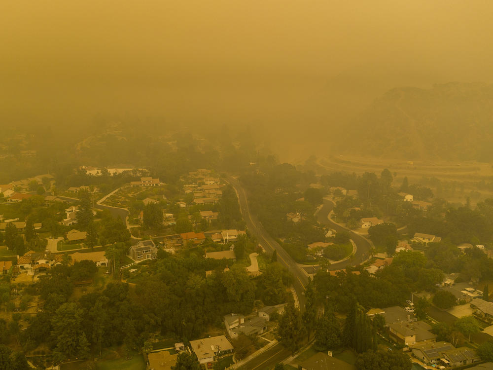 Climate change has been a key factor in increasing the risk and extent of wildfires and other catastrophic weather events. Here, an aerial view shows neighborhoods in Monrovia, Calif., shrouded in smoke from the Bobcat Fire in September.