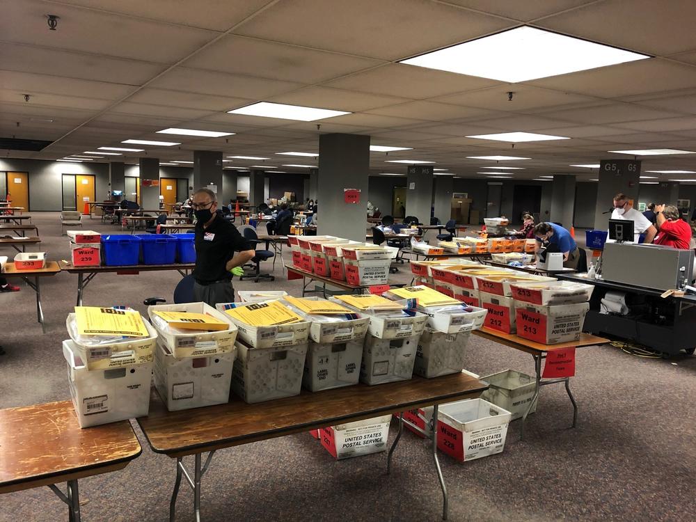 Crates full of absentee ballots that were mailed in or placed into secure ballot drop boxes await to be processed by election officials in Milwaukee on Tuesday.