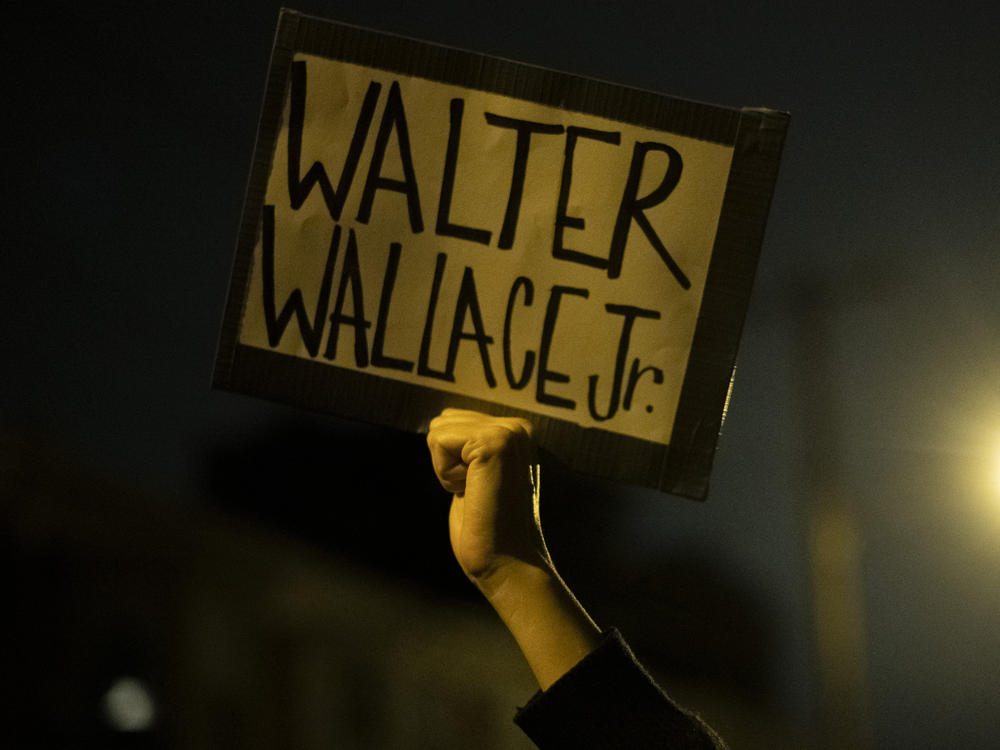 A demonstrator holds a placard with Walter Wallace Jr.'s name on it during a protest near the location where he was killed by two police officers in Philadelphia.