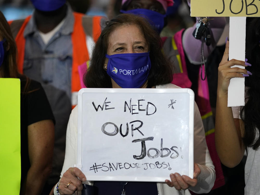 A woman holds a sign saying 