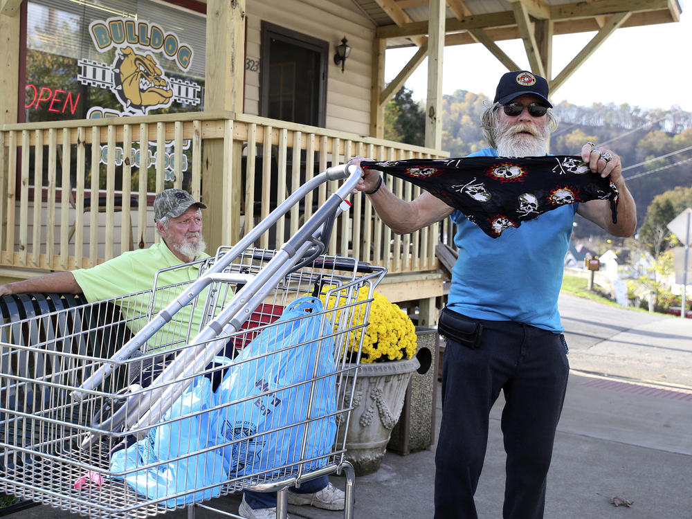 A man displays his face covering for protection against the coronavirus in West Union, W.Va., last month. Small communities from the Dakotas to Kansas to West Virginia have recently seen coronavirus cases rising again.