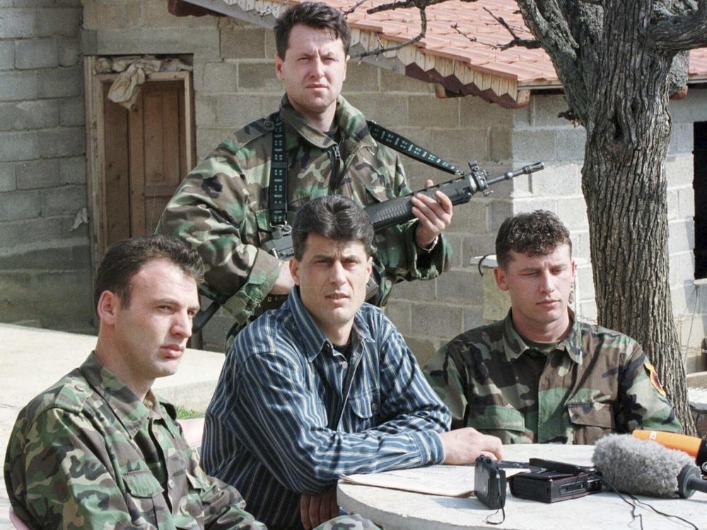 Thaci, center, then a senior commander in the Kosovo Liberation Army guerrilla group, addresses a news conference in 1999 in a secret location in central Kosovo.