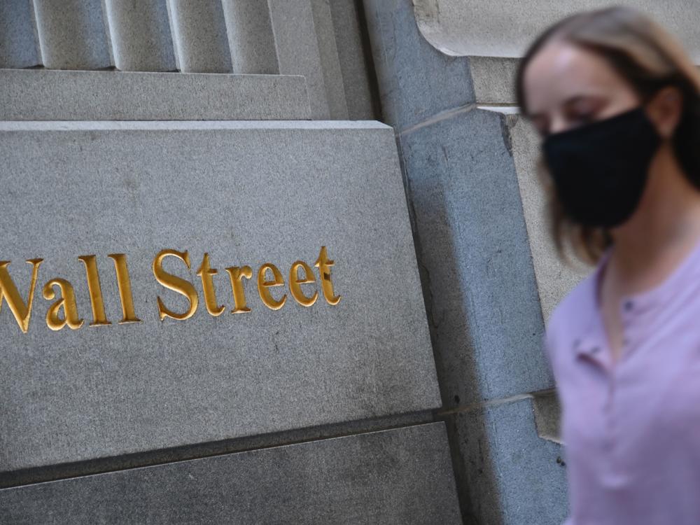 A woman walks by the New York Stock Exchange on Oct. 5. Stock markets are rallying at the prospect that this week's elections will result in a divided government.