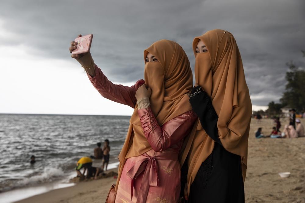 Women take a selfie on the Muslim holiday of Eid al-Fitr on Thailand's Talo Kapo beach.