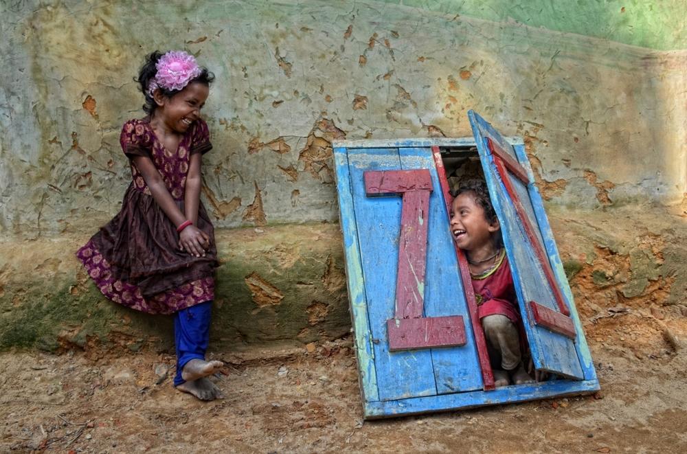 Two girls play in front of a house in Sylhet, Bangladesh.