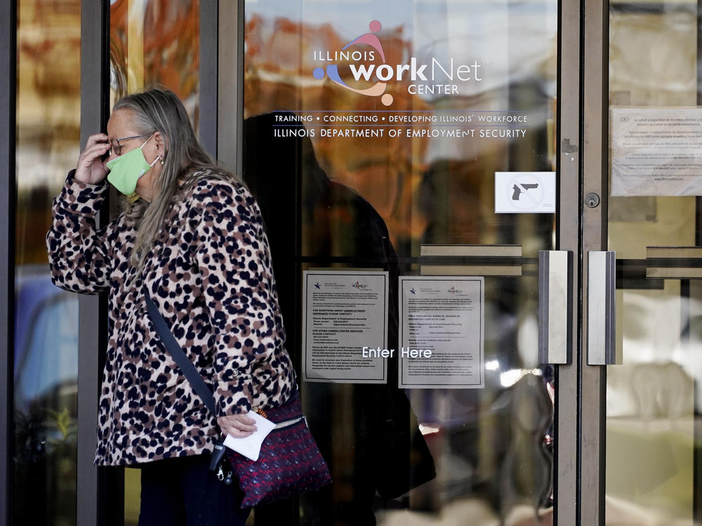 A woman reacts as she leaves the Illinois Department of Employment Security WorkNet center in Arlington Heights, Ill., on Thursday. The state has reported a spike of nearly 10,000 new coronavirus cases. It also reports biggest spike in unemployment claims of all states due to the pandemic.