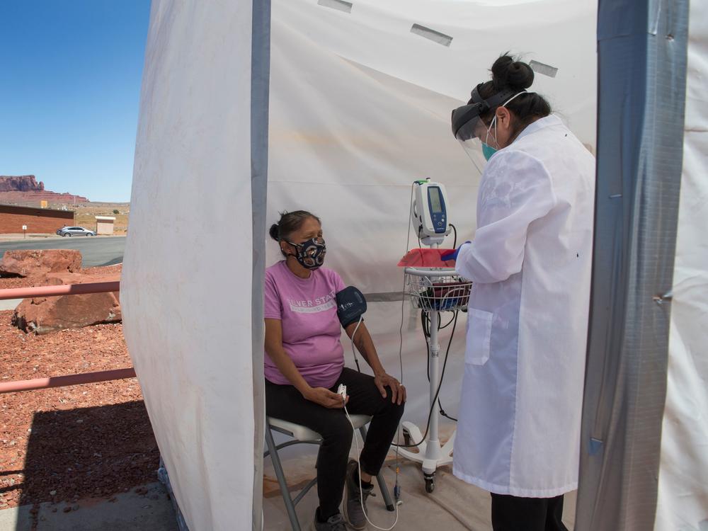 A nurse checks vitals for a Navajo woman, who came to a coronavirus testing center in Arizona, complaining of virus symptoms.