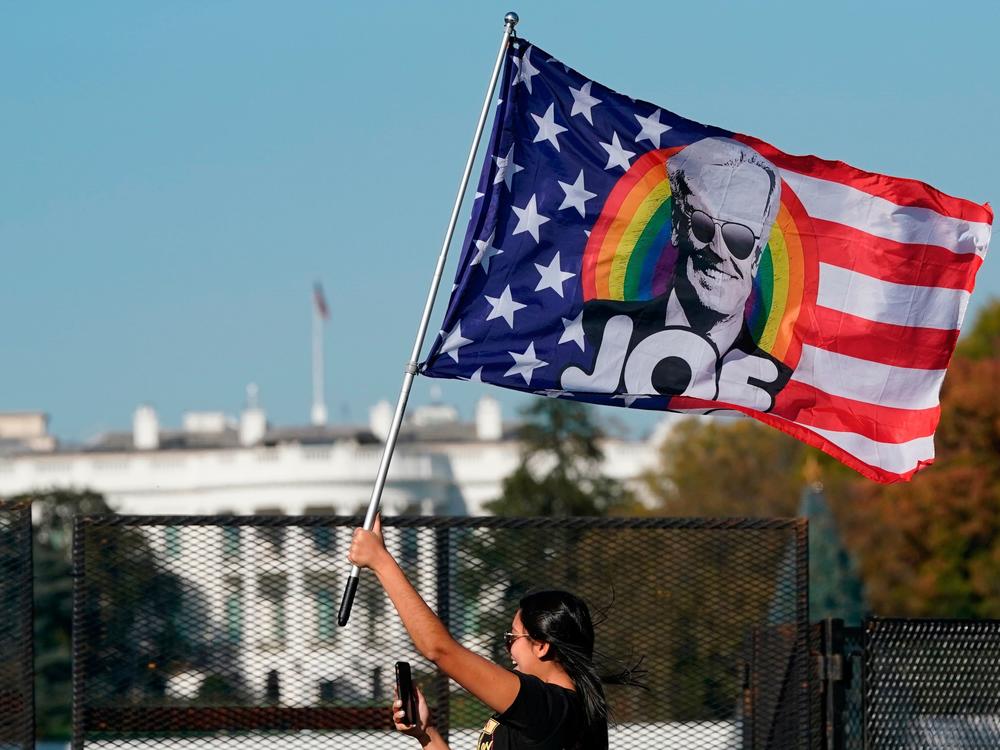 A woman waves a Joe Biden flag during celebrations of his presidential victory on Black Lives Matter Plaza across from the White House on Saturday.