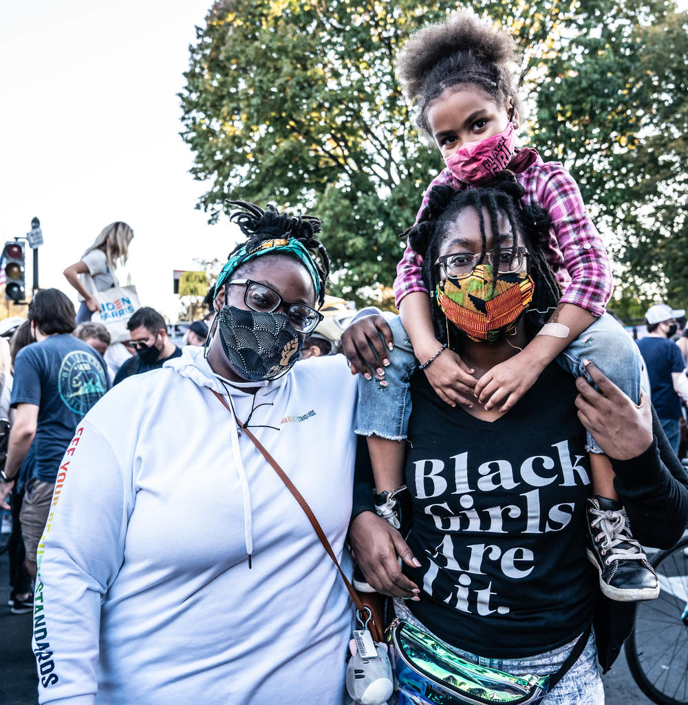 Wynter Smith, 5, Mikaela Smith, left, (Mom of Wynter), Sydney Smith (Black Shirt) stands on Black Lives Matter Plaza to celebrate the victory of Joe Biden.