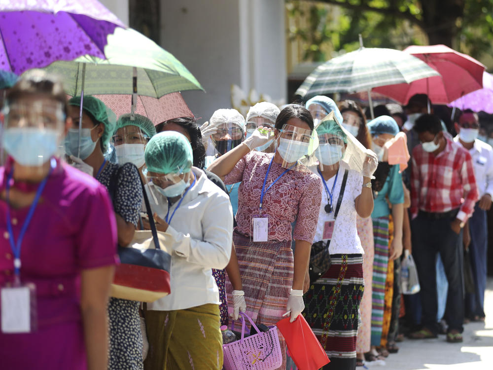 Voters wearing protective face masks line up to cast their ballots at a polling station in Yangon, Myanmar, on Sunday. Turnout was reportedly higher than expected, given concerns over voter safety during the coronavirus pandemic.