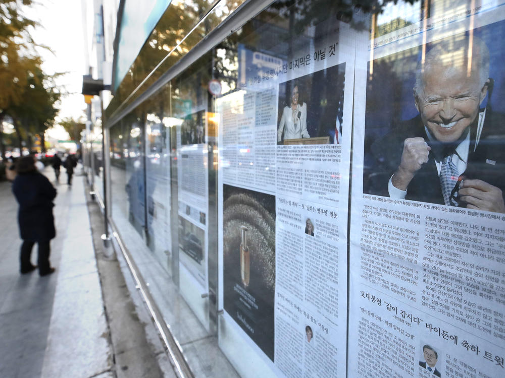 A newspaper's front page featuring President-elect Joe Biden and Vice President-elect Kamala Harris is displayed on a sidewalk in Seoul, South Korea, on Monday.