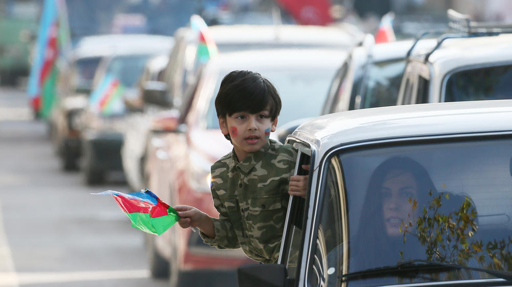 A child with an Azerbaijani flag looks from a car during a celebration marking the end of the military conflict over Nagorno Karabakh, in Ganja, Azerbaijan, on Tuesday.