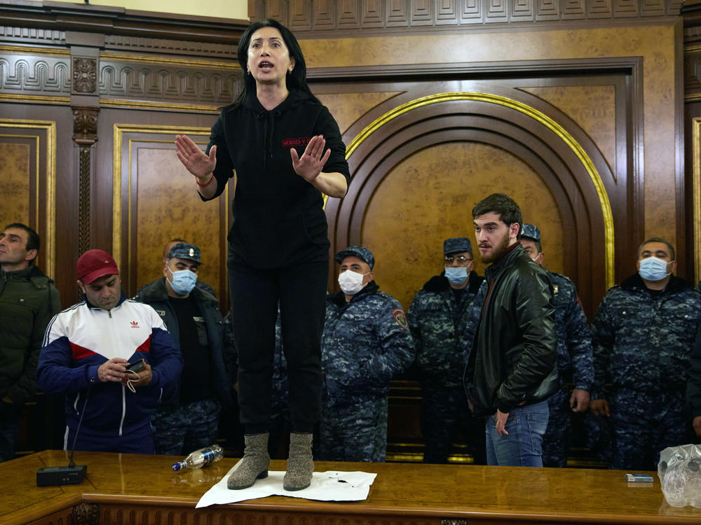 Police look on as a woman shouts among protesters who have stormed Armenian Prime Minister Nikol Pashinyan's office after the announcement of a peace deal in the war between Armenia and Azerbaijan on Tuesday.